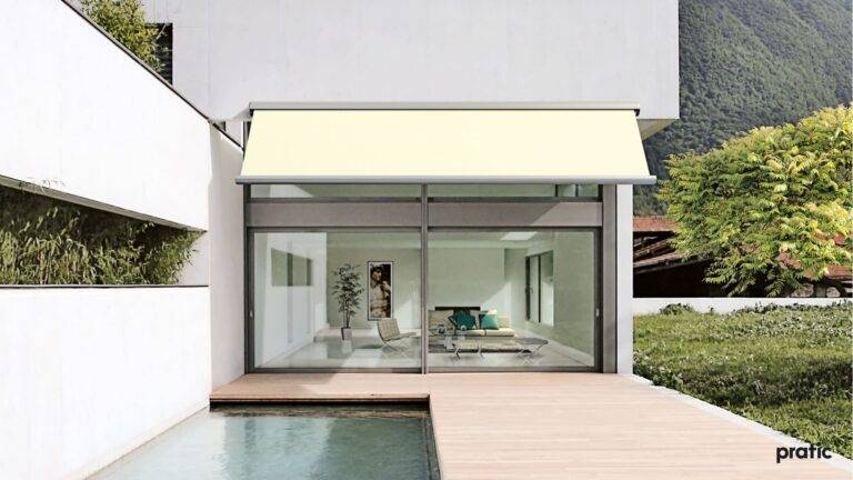 Terrasse mit einer kleinen Wasserfläche daneben, mit Blick auf eine verglaste Front.