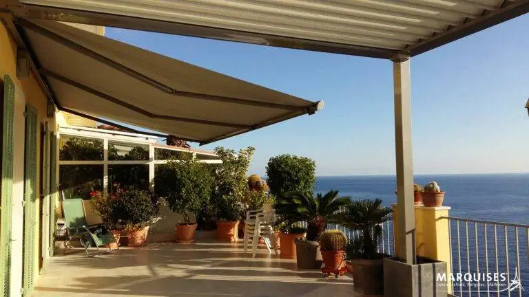 Markisen auf einer Terrasse, erleuchtet mit warmen Licht der Sonne mit Blick auf das Meer