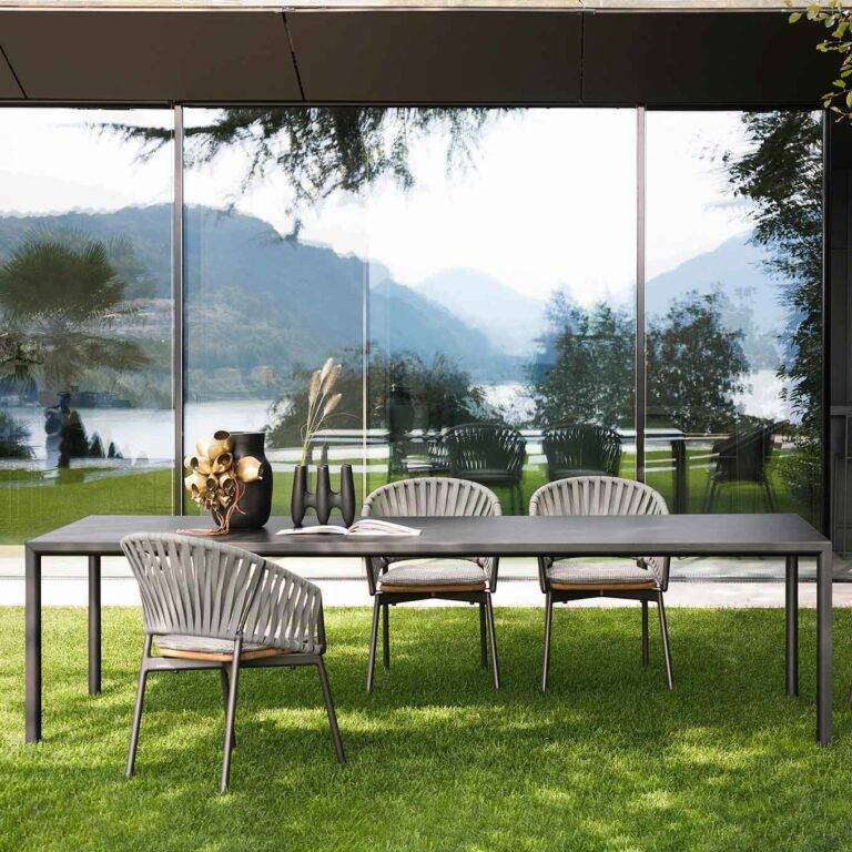 Stühle und Tische stehen unter einem Pavillon mit Blick auf Berge und See