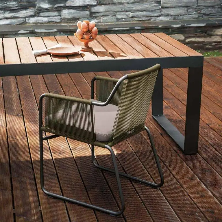 Der Stuhl steht auf einer Holzterrasse am Tisch