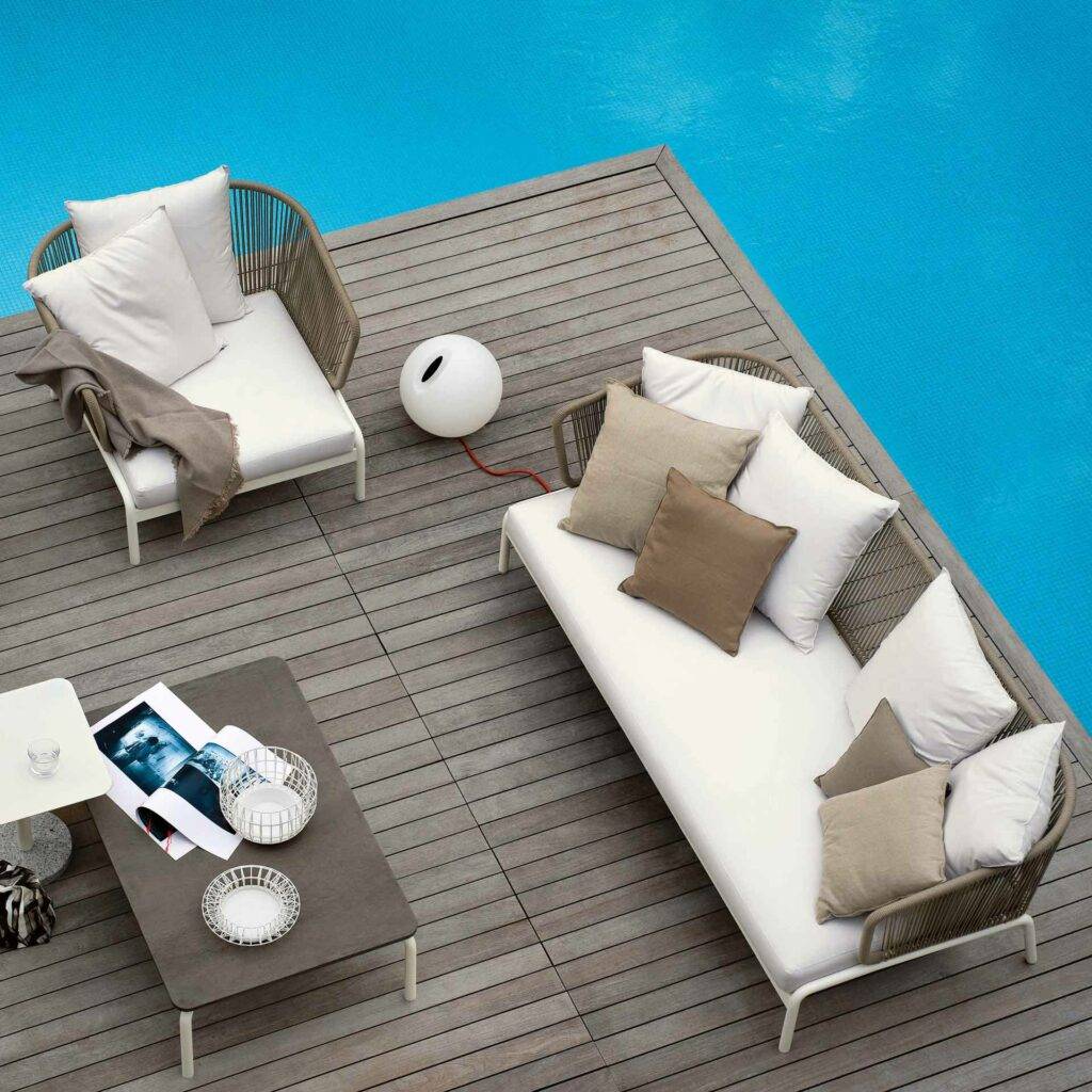 Helle Outdoor Möbel auf einer Terrasse mit Pool daneben