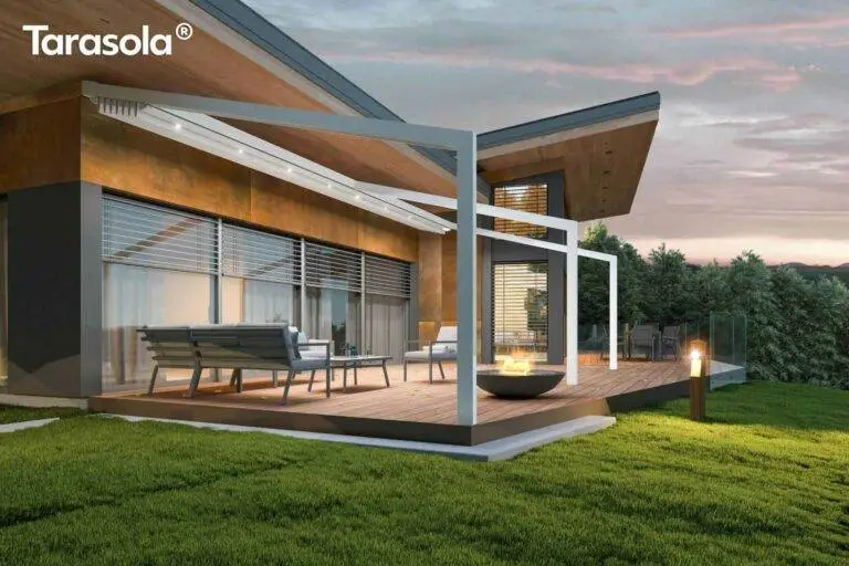 Offene Terrassenüberdachung in der Dämmerung, beleuchtet, Rasen im Vordergrund und Bäume im Hintergrund