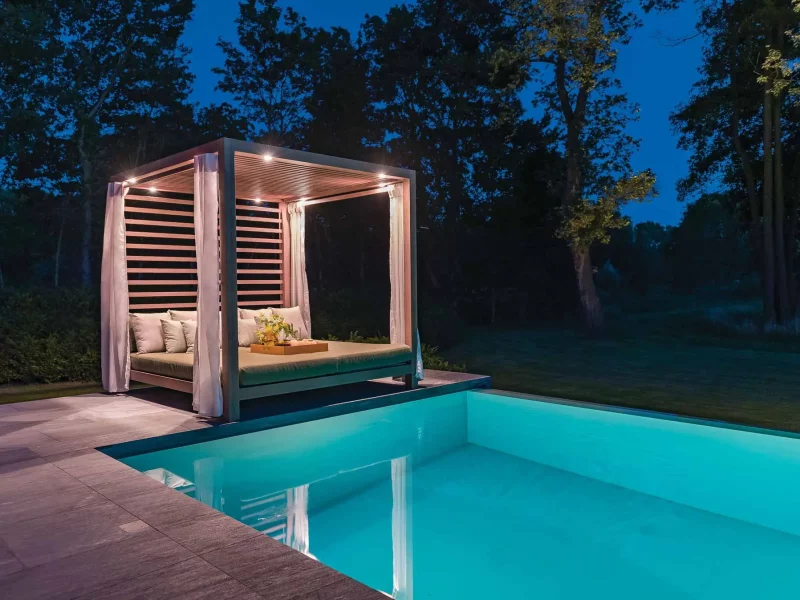 beleuchtete Überdachung über Möbeln am Pool in der Nacht